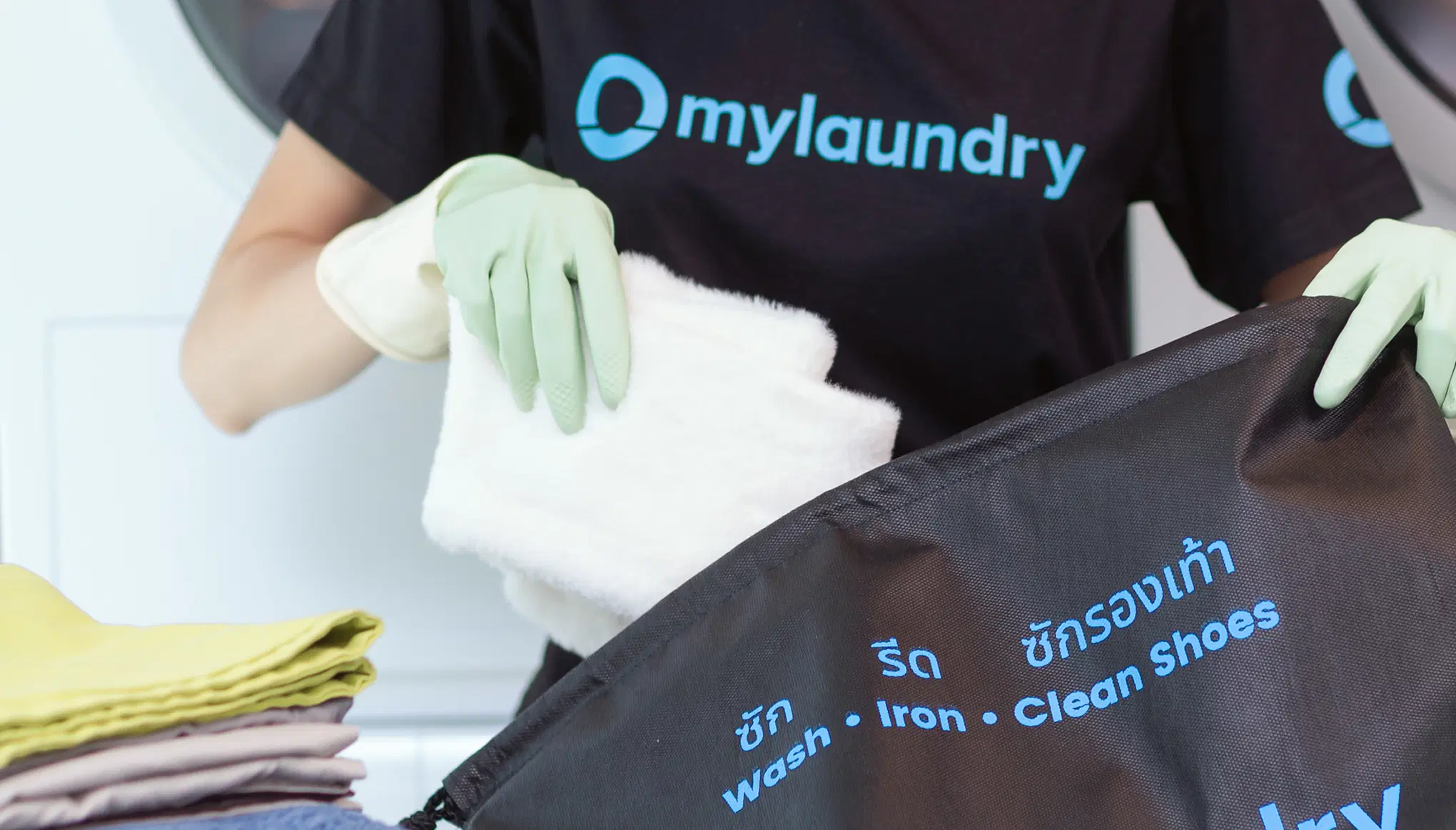 A My Laundry staff member loading a dryer